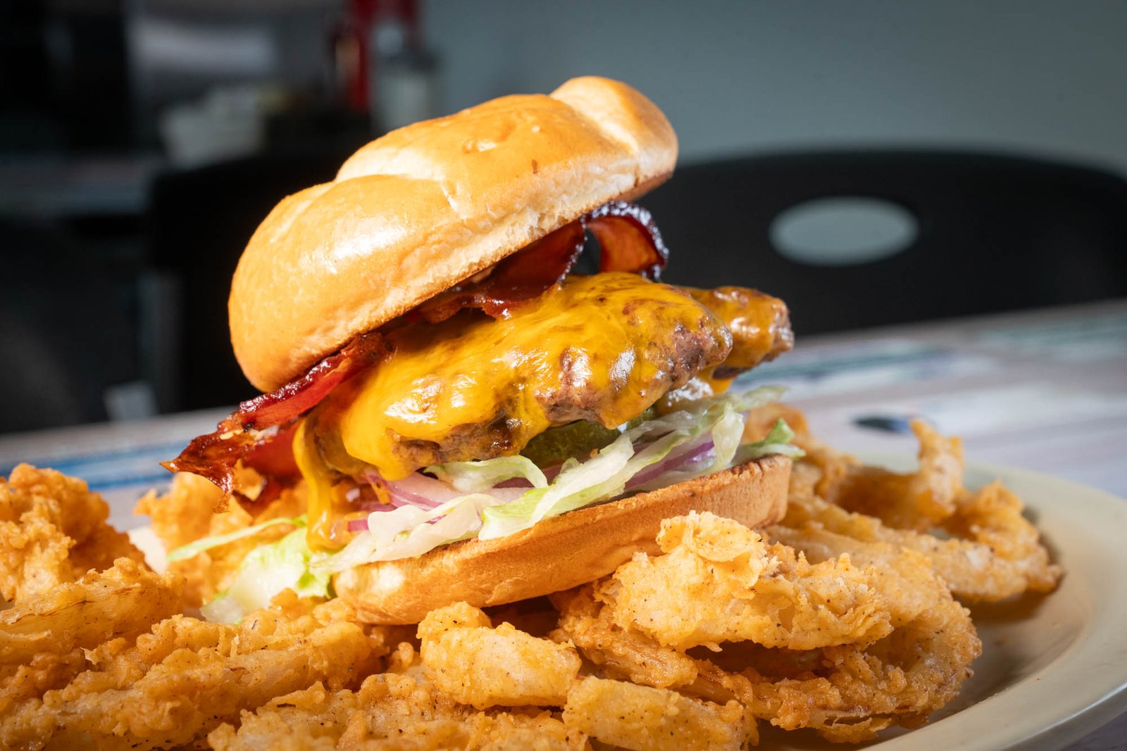 Bacon cheeseburger served with crispy onion rings